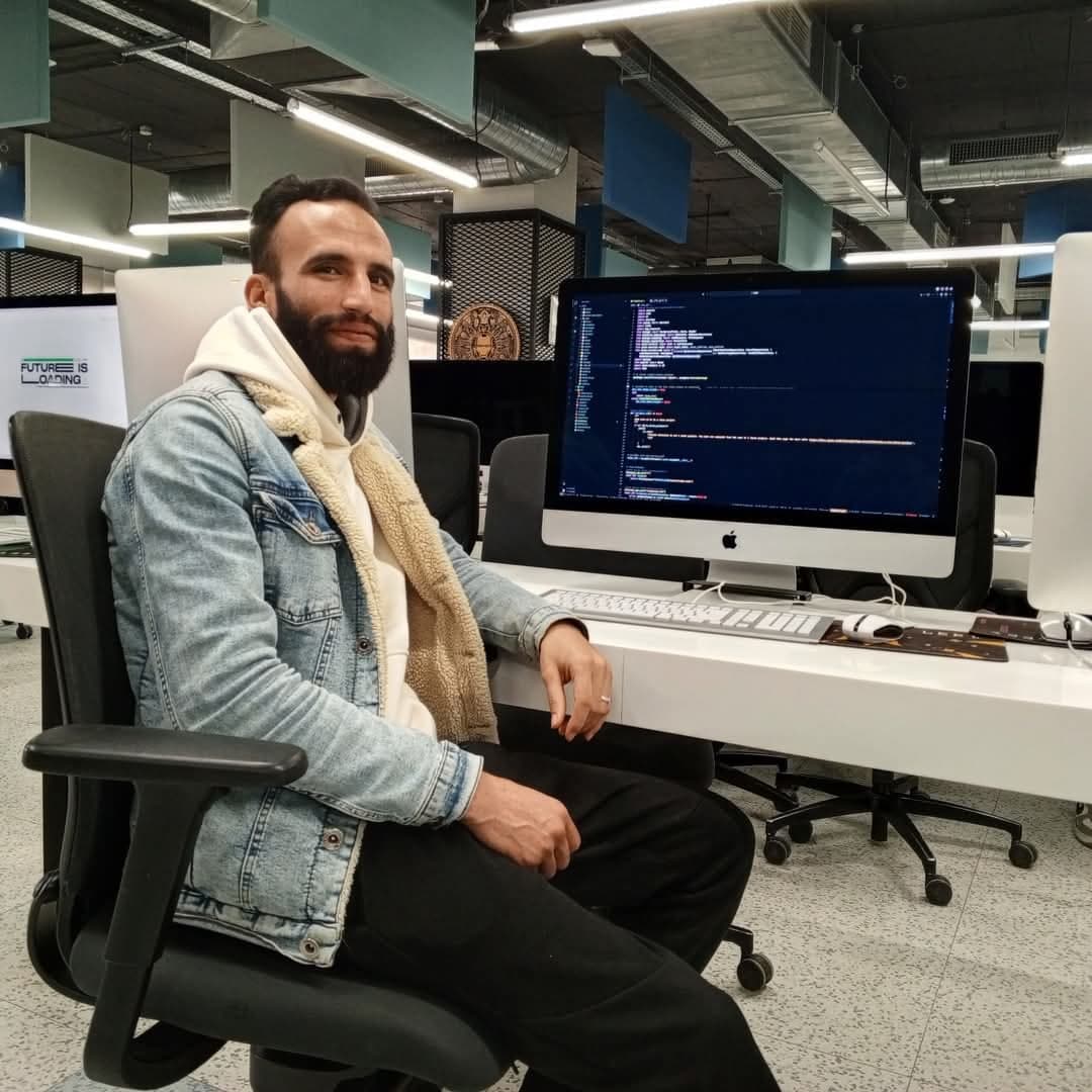 Ismail Essabar at a workstation in an open-plan office