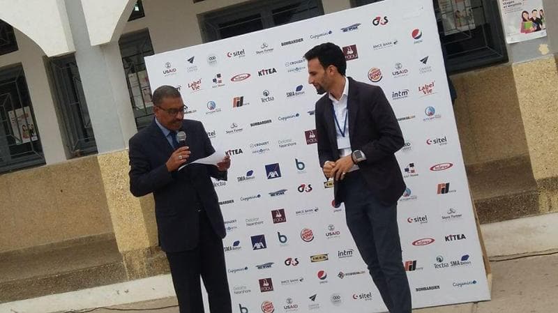 Ismail Essabar on stage at a careers event in front of a sponsor wall
